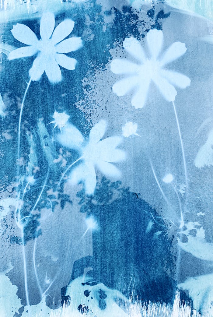 Vintage cyanotype art featuring delicate floral patterns in blue tones.